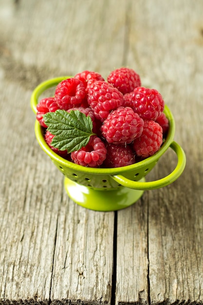 Free photo fresh raspberries in green colander