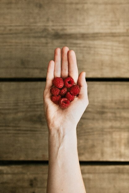 Fresh raspberries on a woman's hand