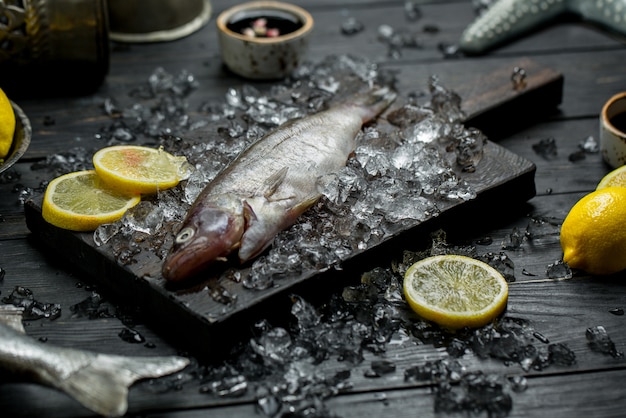 Fresh raw fish with lemon slices and minced ice cubes.