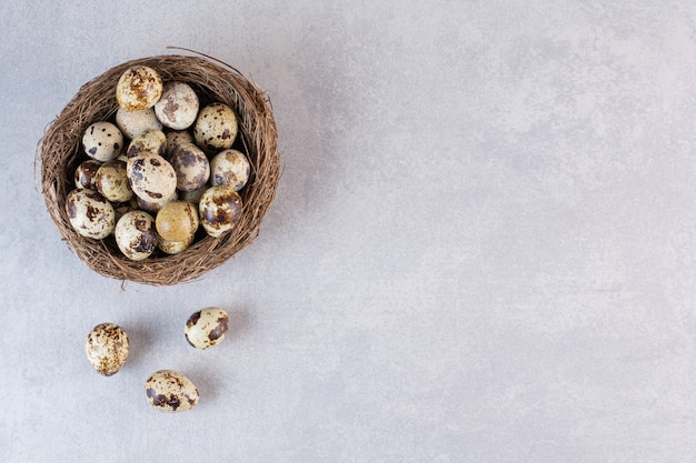 Fresh raw quail eggs placed on a stone table .