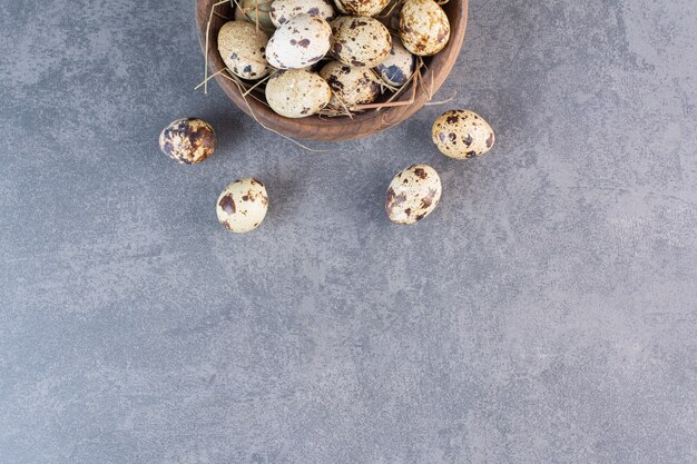 Fresh raw quail eggs placed on a stone table .