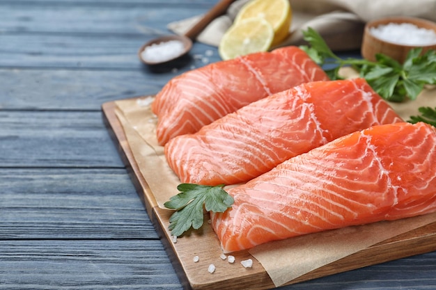 Fresh raw salmon with parsley on blue wooden table Fish delicacy