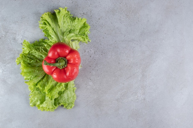 Free photo fresh red bell pepper with lettuce on a gray background. high quality photo