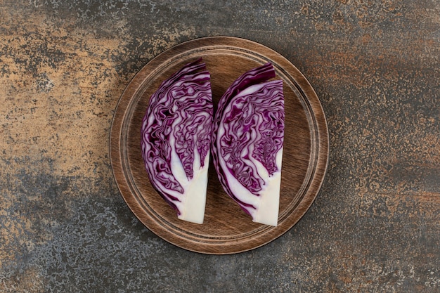 Fresh red cabbage chopped on a board  on the marble surface