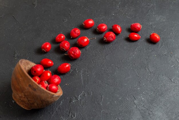 Fresh red cherry fruit in a brown bowl on gray background