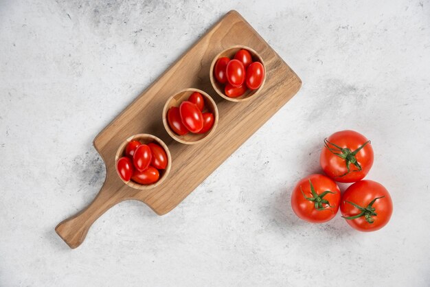 Fresh red cherry tomatoes in wooden bowls.