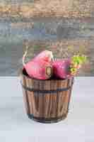 Free photo fresh red radishes in wooden bucket. high quality photo