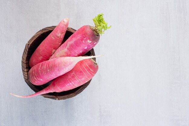 Fresh red radishes in wooden bucket. High quality photo