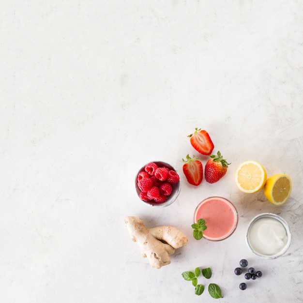 Free photo fresh red smoothie with ingredients top view