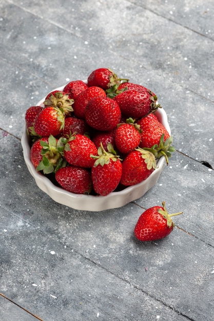 fresh red strawberries mellow and ripe fruits inside plate on grey desk