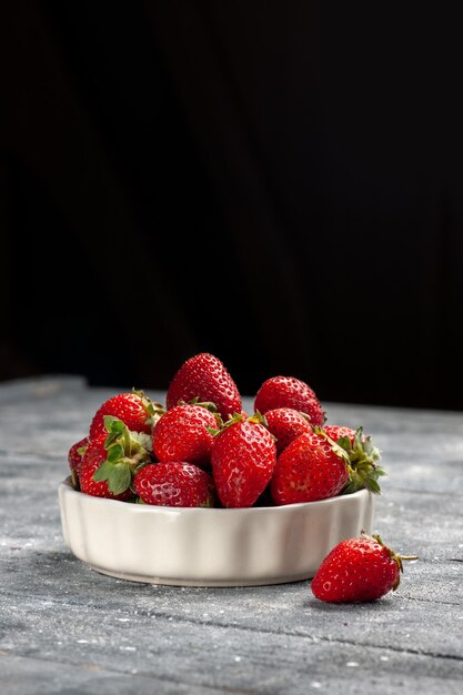 fresh red strawberries mellow and ripe fruits inside plate on grey desk