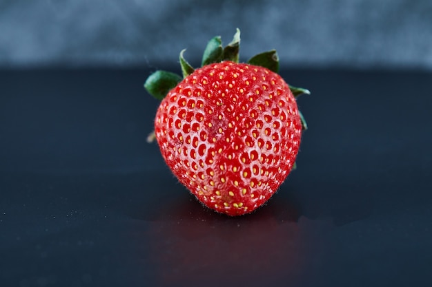 Fresh red strawberry on dark surface. Close up