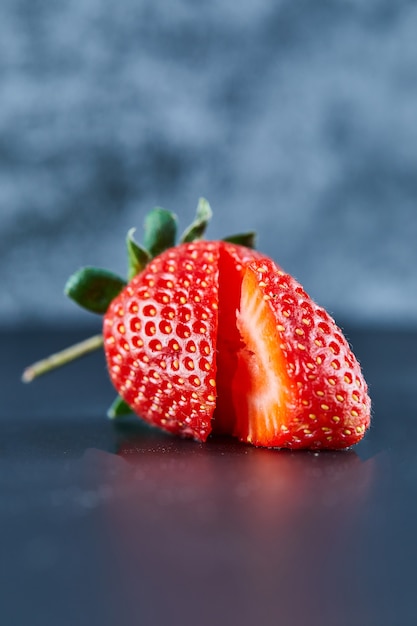 Fresh red strawberry slices on dark surface