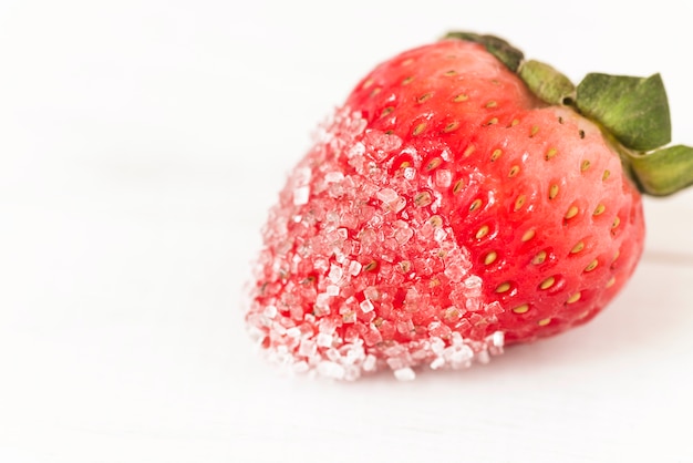 Fresh red strawberry with sugar on white background