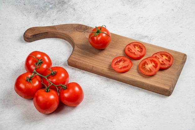 Fresh red tomatoes on a wooden cutting board