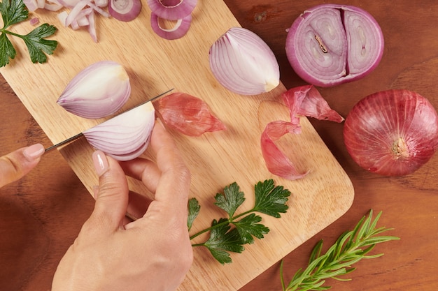 Free photo fresh red whole and sliced onion. sliced red onion with parsley and rosemary . onion and slices on wooden cutting board. freshly picked from home growth organic garden. food concept.