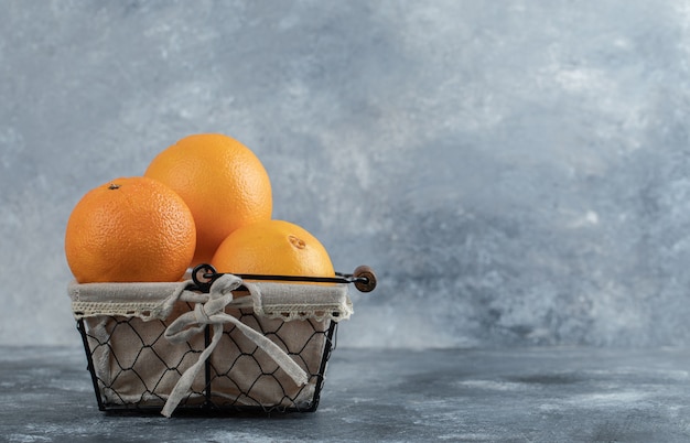 Free Photo fresh refreshing oranges in basket on marble table. 