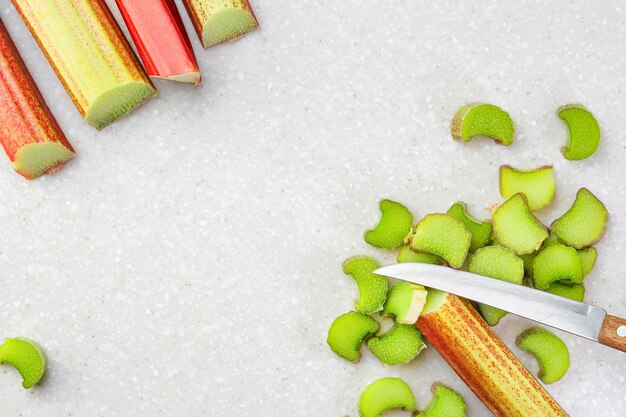 Fresh rhubarb stalks laying out on a cutting table the process of preparing homemade seasonal pastries View from above