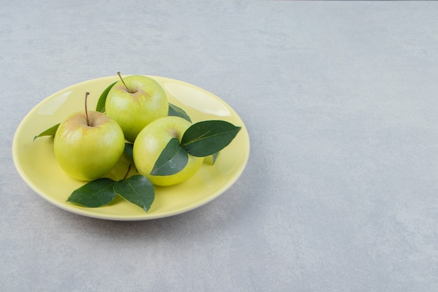 Fresh ripe apples on yellow plate. 