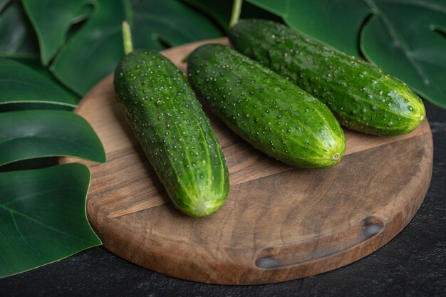 Fresh ripe cucumbers on wooden board. 