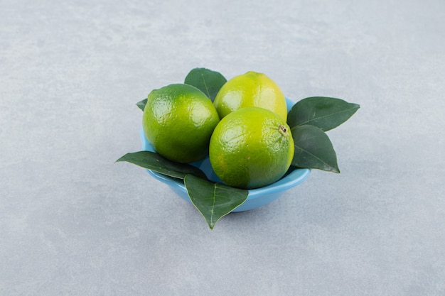 Fresh ripe limes in blue bowl