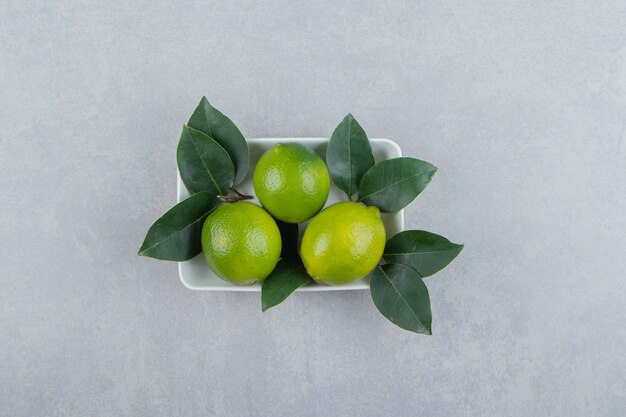 Fresh ripe limes on white plate