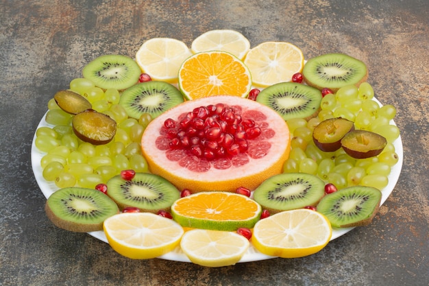 Fresh ripe slices of fruits on white plate. High quality photo