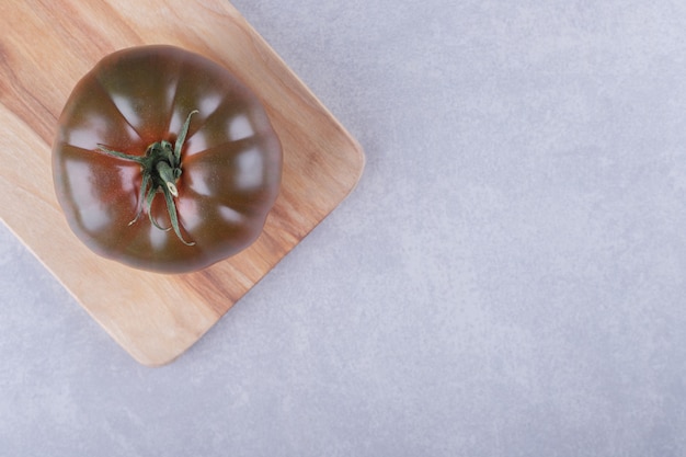 Fresh ripe tomato on wooden board. 