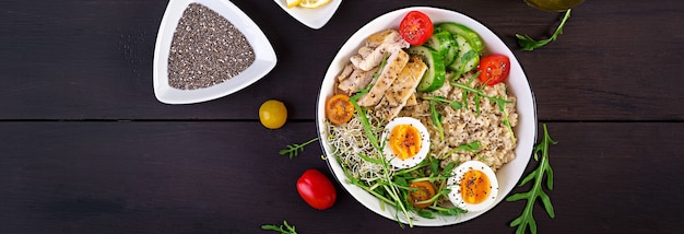 Free Photo fresh salad. breakfast bowl with oatmeal, chicken fillet, tomato, lettuce, microgreens and boiled egg. healthy food. vegetarian buddha bowl.