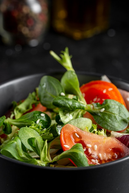 Fresh salad in dark bowl close-up