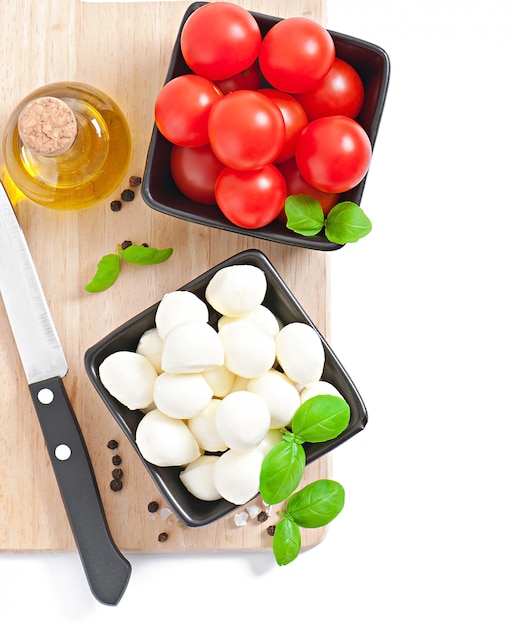 Free photo fresh salad with cherry tomatoes, basil, mozzarella and black olives.