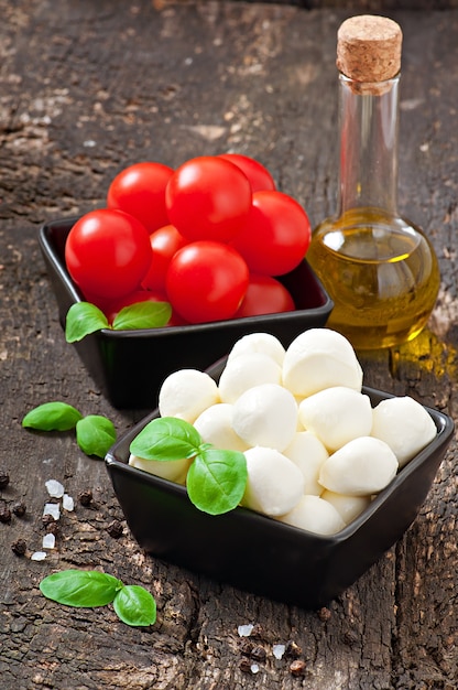 Free Photo fresh salad with cherry tomatoes, basil, mozzarella and black olives.