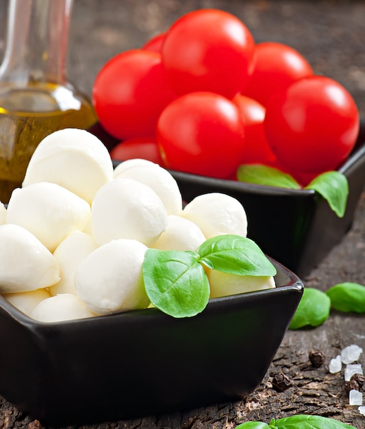 Free photo fresh salad with cherry tomatoes, basil, mozzarella and black olives.