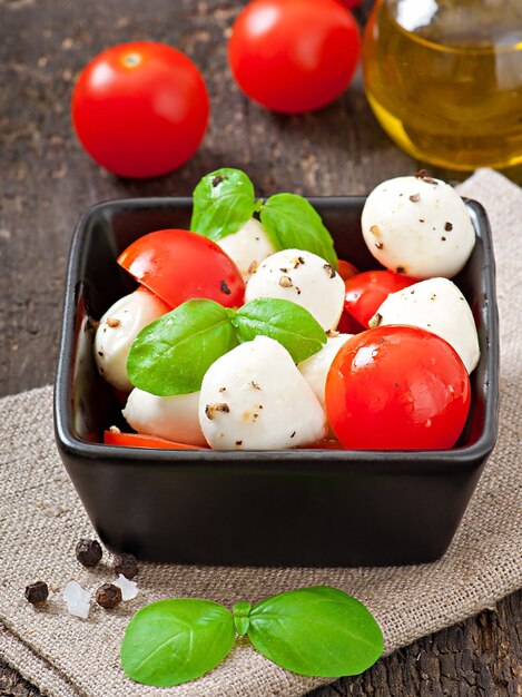 Fresh salad with cherry tomatoes, basil, mozzarella and black olives.