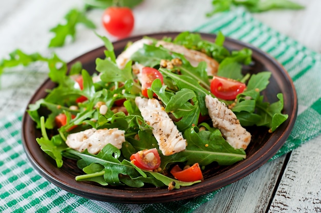 Fresh salad with chicken breast, arugula and tomato