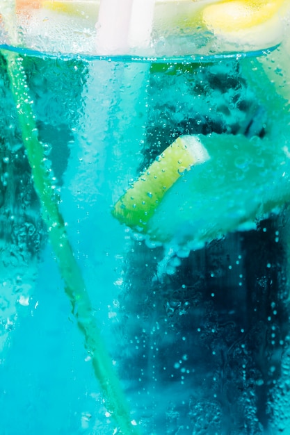 Free Photo fresh slice of lemon floating in blue cold cocktail with bubbles