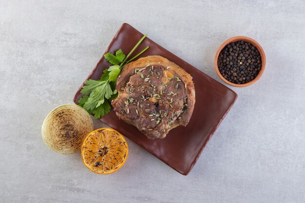 Fresh sliced meat with fresh vegetables placed on a stone table. 