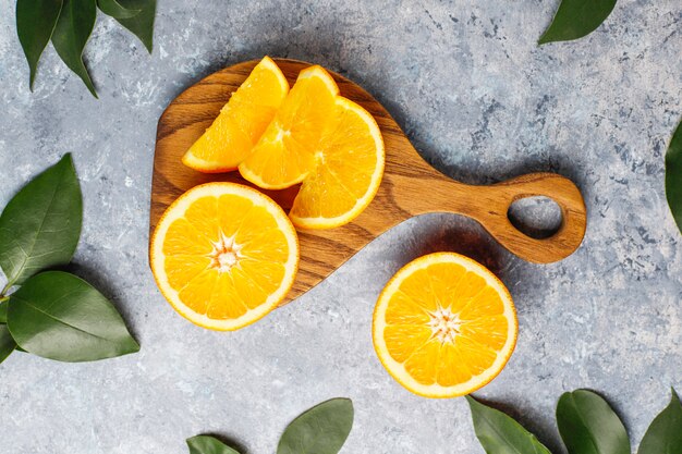 fresh sliced oranges on cutting board on concrete surface 