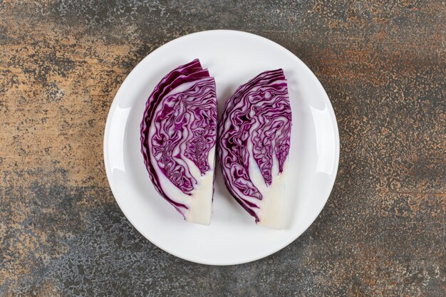 Fresh sliced red cabbage in the plate on the marble surface