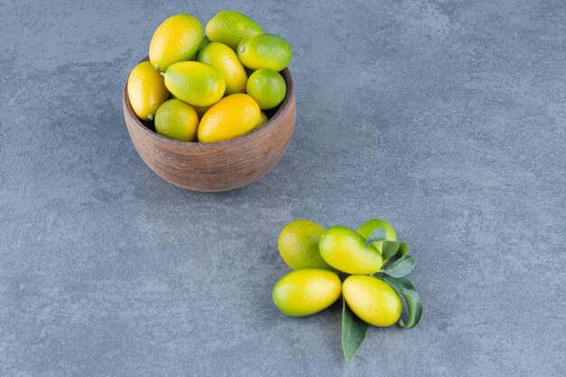 Fresh small tangerines in wooden bowl.