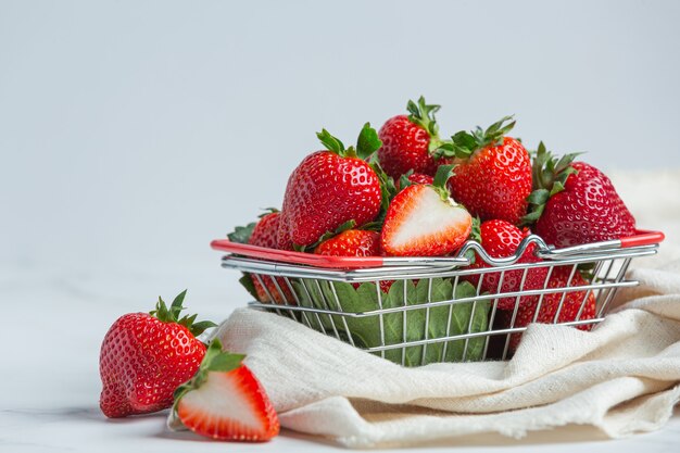 Fresh strawberries in a bowl on white background