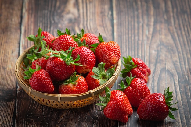 Fresh strawberries in a bowl on wooden table