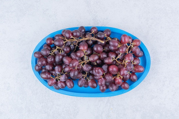 Free photo fresh sweet grapes in blue plate on white background. high quality photo