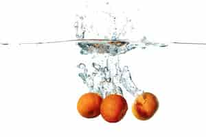 Free photo fresh tangerine fruits falling in water splash