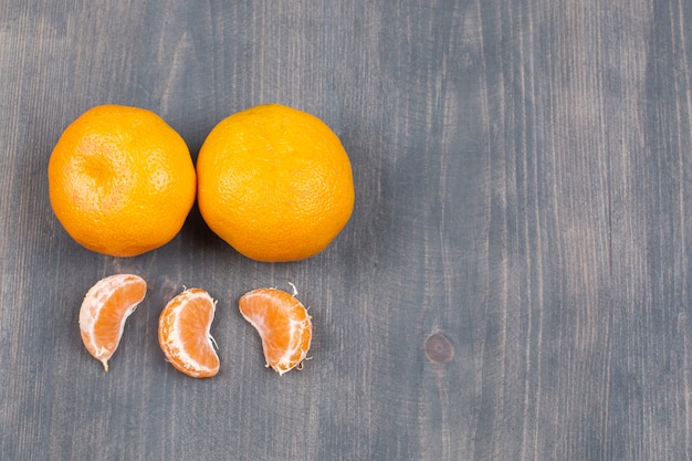 Free Photo fresh tangerines and segments on wooden table