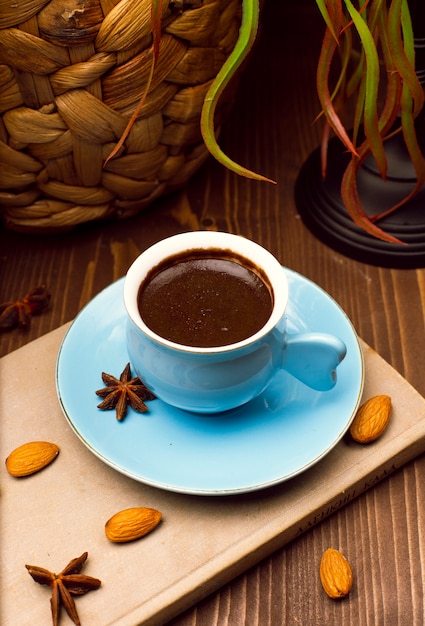 Fresh tasty espresso. blue cup of hot coffee with almonds and anis