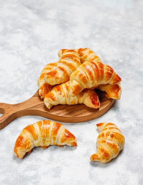 Fresh tasty homemade croissants on grey-white . French pastry