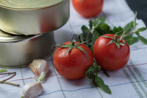 Free photo fresh tomatoes with garlic and greens on a tablecloth .