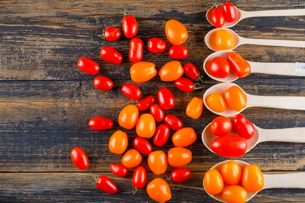 Fresh tomatoes in wooden spoons on a wooden table. flat lay.