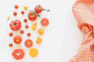 Free photo fresh vegetables and checkered pattern napkin on white backdrop